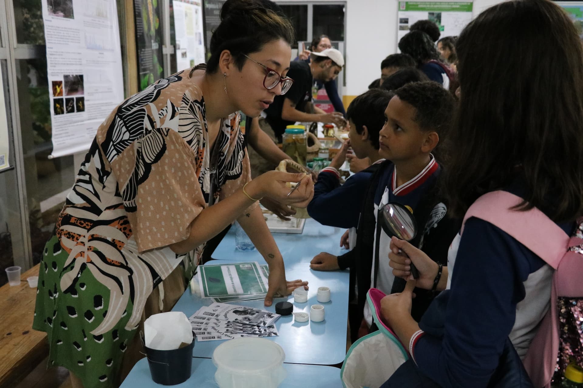 Pesquisadora apresentando material biológico a crianças