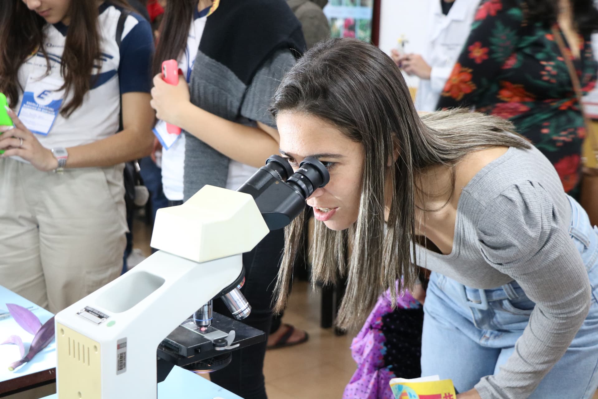 Visitante observando amostra em microscópio